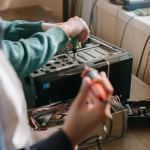 Bir teknisyenin telefonu açıp parçalarını kontrol ettiği çalışma masası